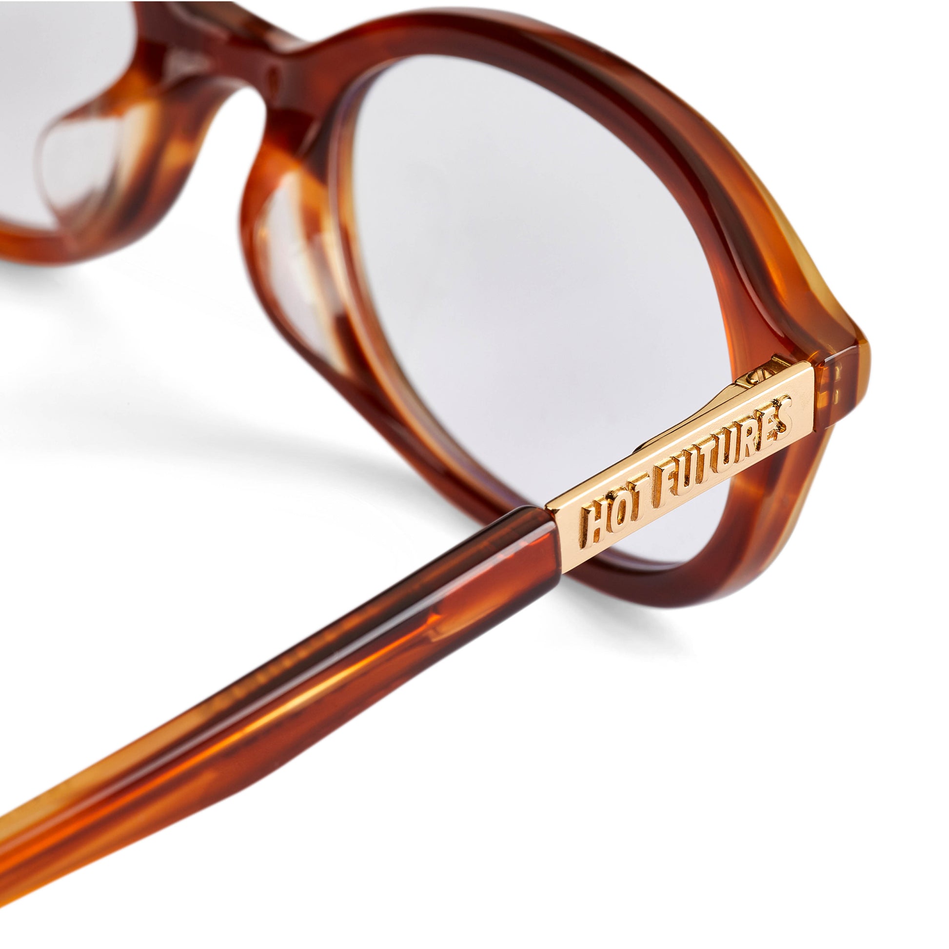 Close up shot of the cupid caramel eye glasses with the gold Hot Futures branding to the side arms.