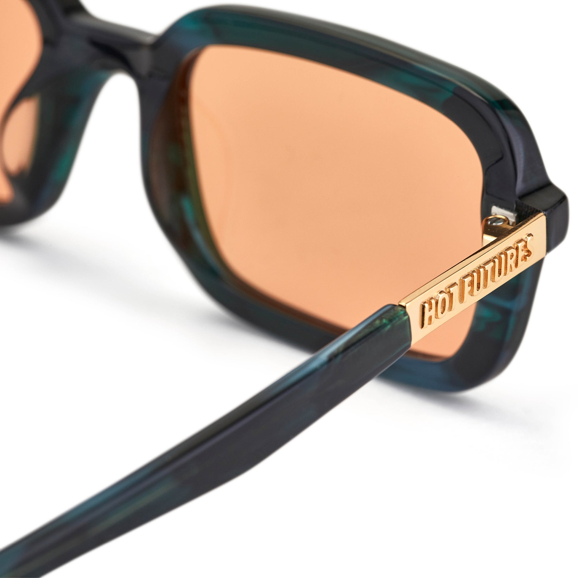 A pair of sunglasses with green crystal frame and orange tinted lenses, with a Y2K inspired soft slim rectangle frame.