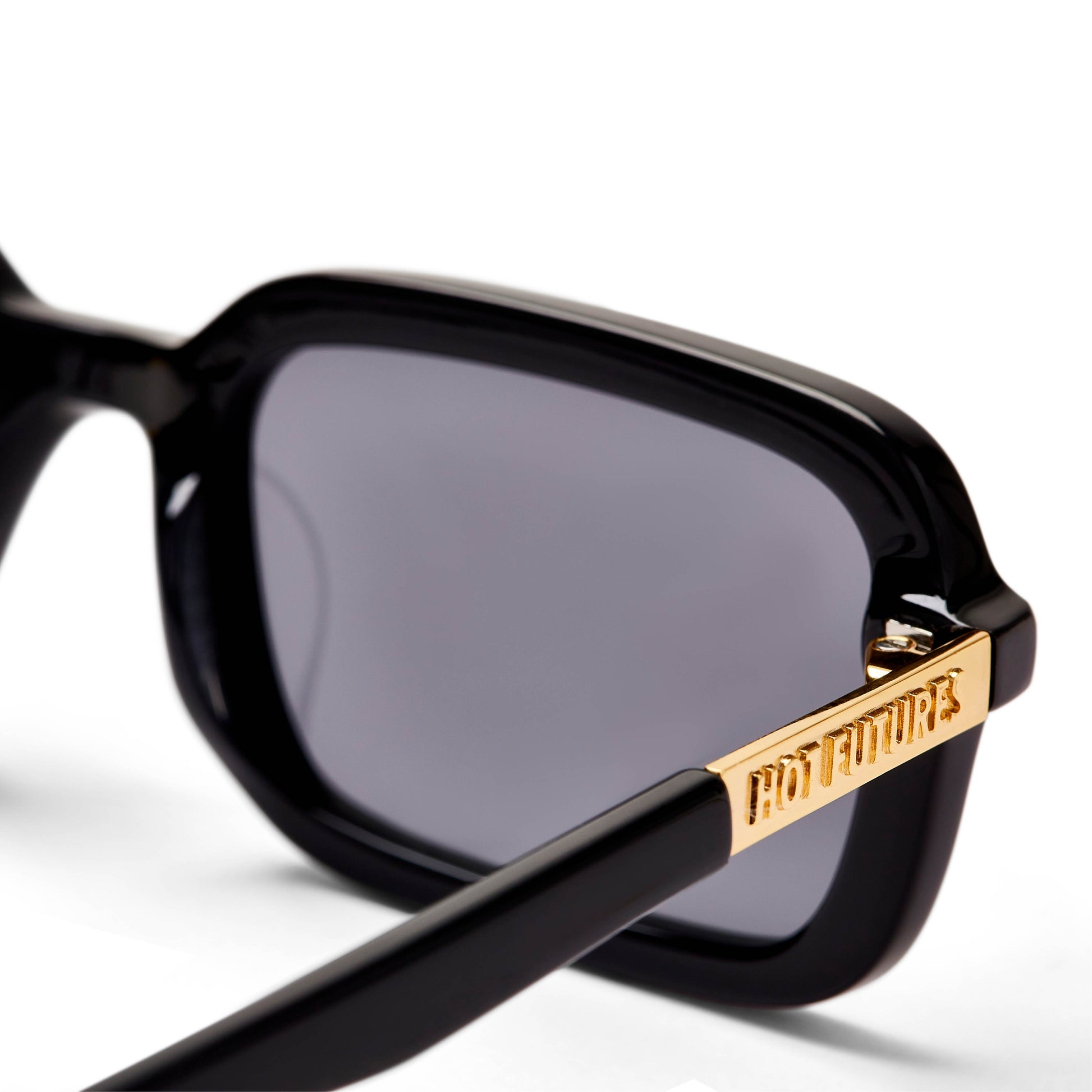 A pair of black rectangular sunglasses with smoke tinted lenses, designed in London