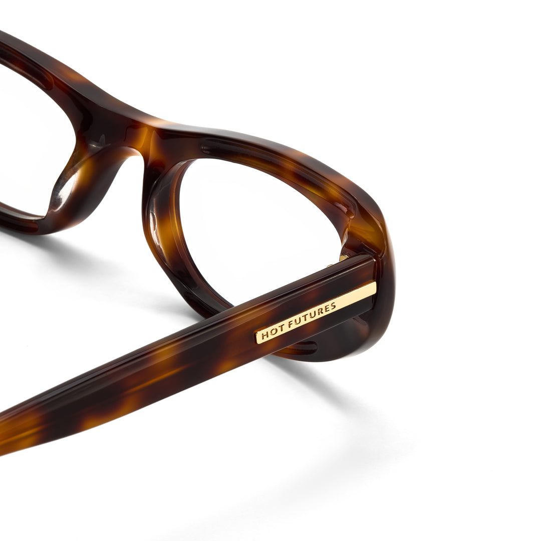 Close-up of tortoiseshell glasses with 'HOT FUTURES' label on a white background