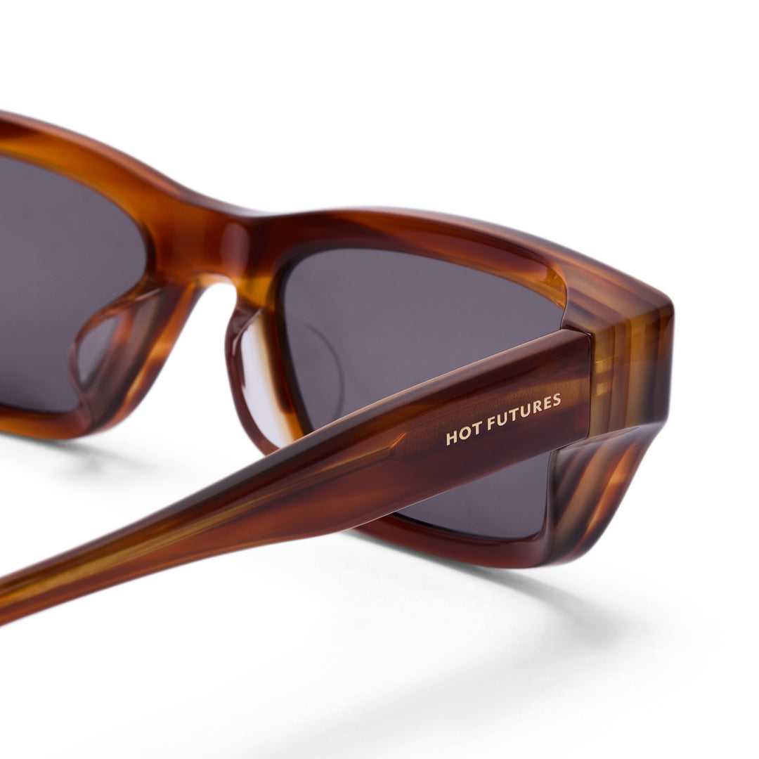 Sunglasses with tortoiseshell frame and dark lenses on a white background, featuring 'HOT FUTURES' branding.