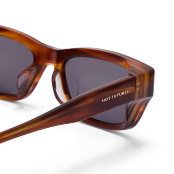 Sunglasses with tortoiseshell frame and dark lenses on a white background, featuring 'HOT FUTURES' branding.
