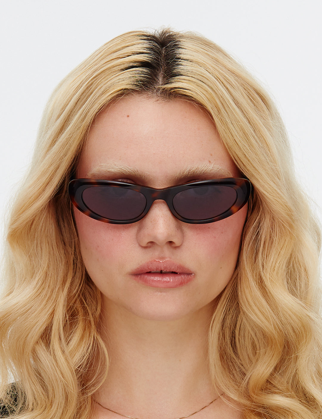 Sunglasses with tortoiseshell frame and dark lenses on a white background