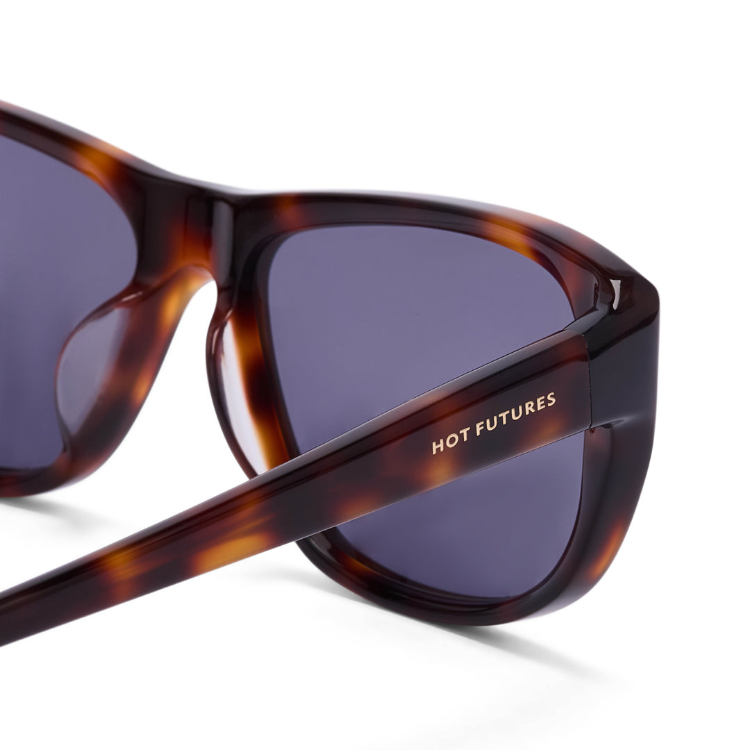 Sunglasses with tortoiseshell frame and dark lenses on a white background, featuring 'Hot Futures' branding.